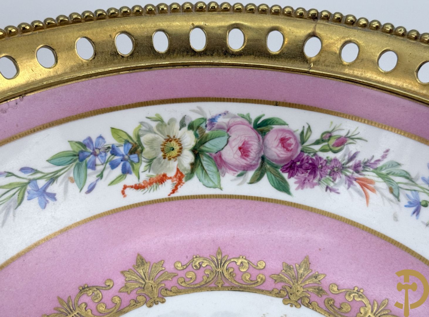 Porseleinen coupe met centraal tafereel en omringd met bloemendecor, gevat in bronzen houder