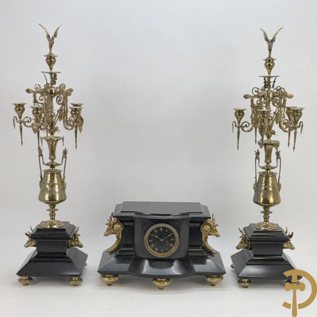 Zwart marmeren garnituur Napoleon III bestaande uit paar bronzen vuurrvergulde vijfarmige kandelaars bezet met vogels op zwarte marmeren basis met hertenkoppen + zwart marmeren middenstuk met klok bezet met hertenkoppen (zonder beeld)