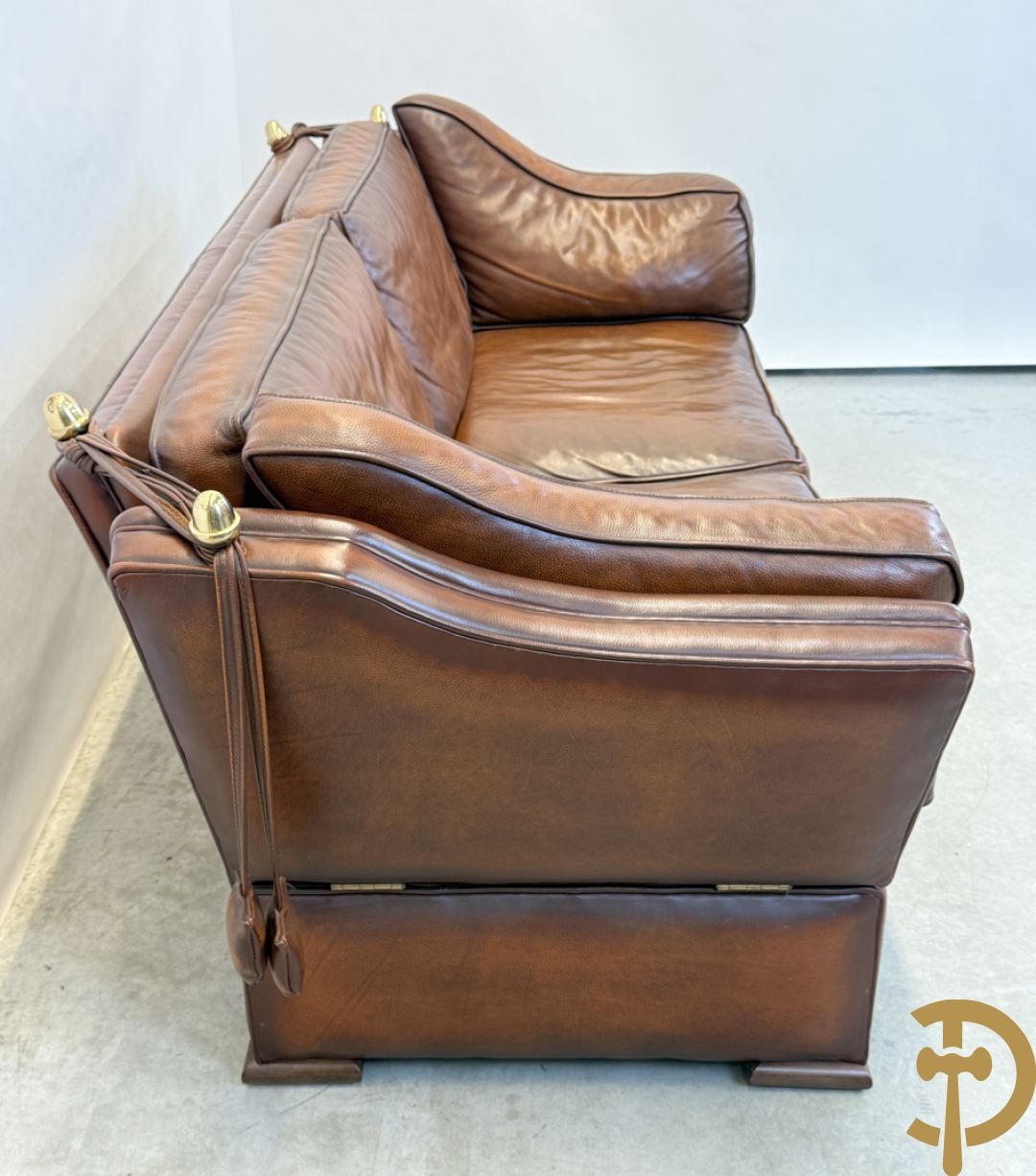 Bruin lederen canapé met kantelbare zijkanten en koperen denappels