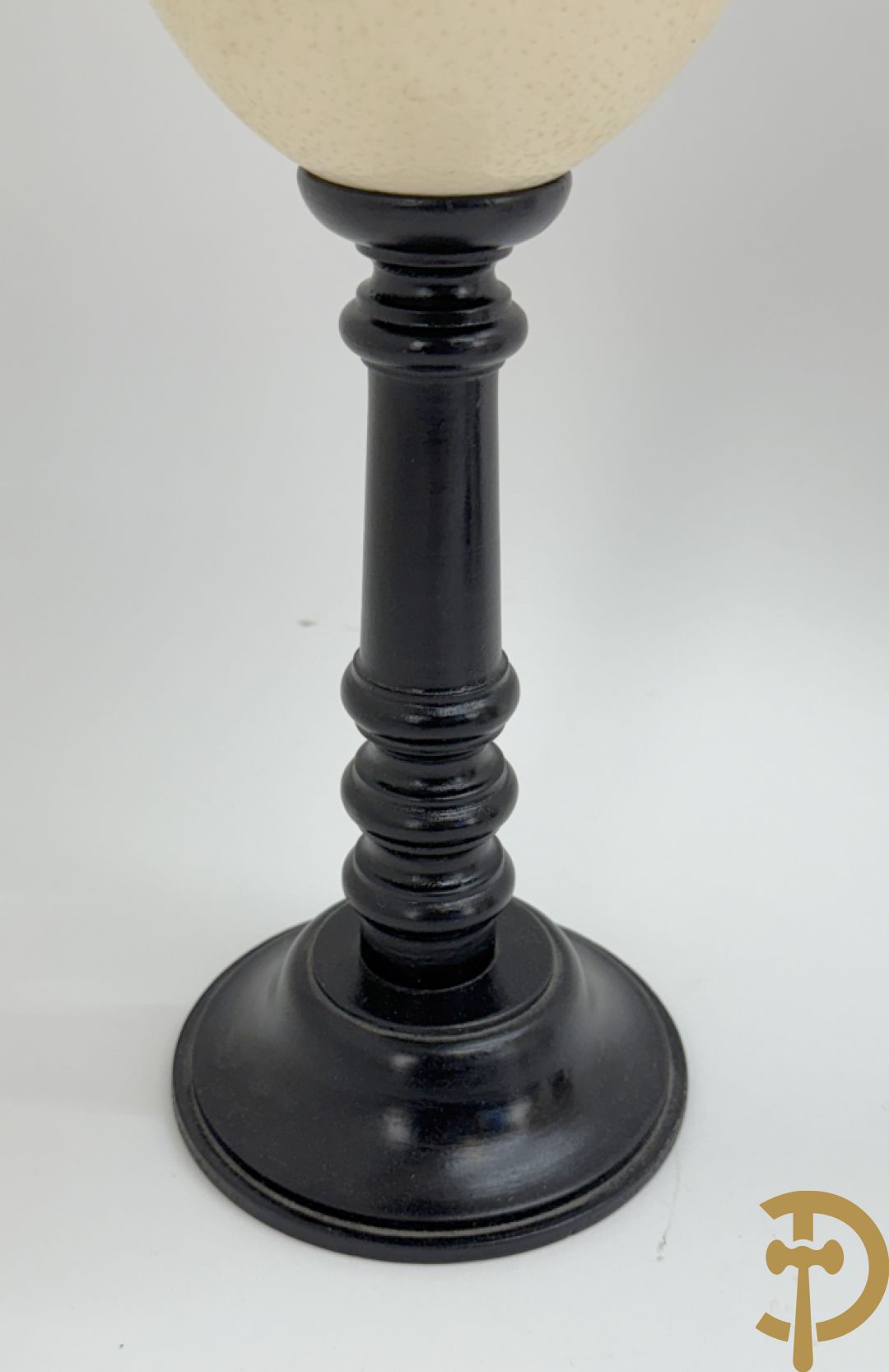 Vijf struisvogeleieren op zwart houten statief