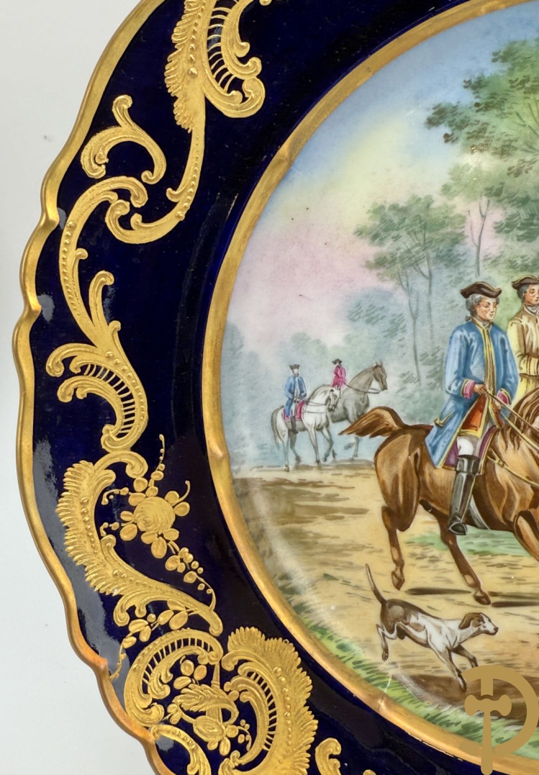Paar porseleinen borden met ruitertafereel met vergulde omranding, getekend Rivière en Bourdier P., achteraan gemerkt met gekruiste pijlen