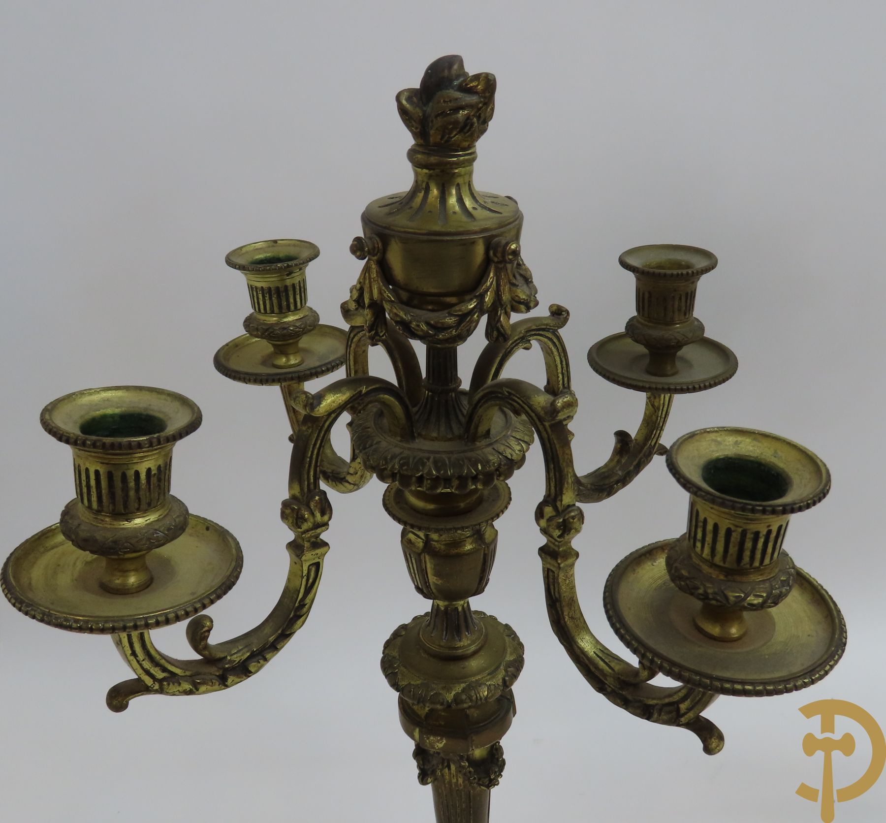 Paar bronzen Louis XVI vierarmige kandelaars bezet met toorts bovenaan