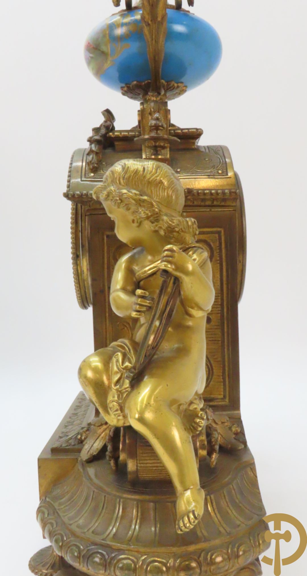 Driedelige bronzen garnituur bezet met Sèvres porselein bestaande uit pendule geflankeerd door paar cupido