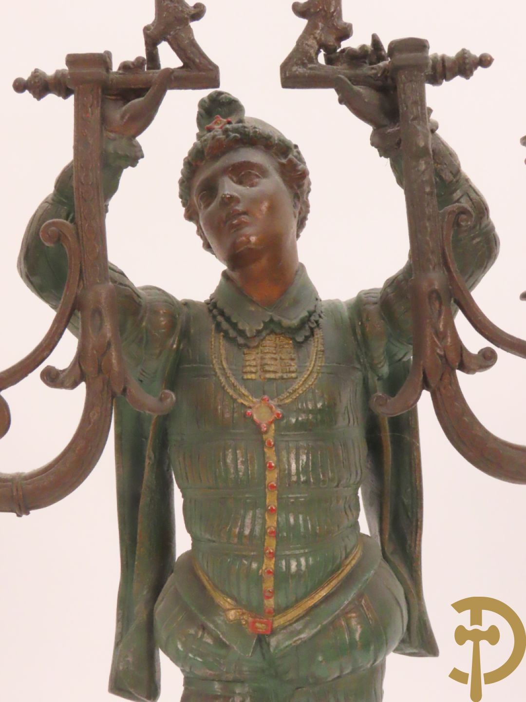 Driedelige kunstbronzen garnituur bestaande uit pendule met paar schakende edelheren, bezet met kariatiden - geflankeerd door paar driearmige kandelaars gehouden door 2 edelheren