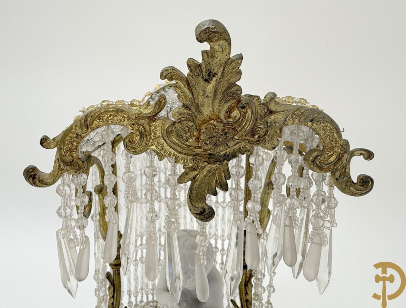 Biscuitbeeld van schrijvende cupido onder bronzen dakje met kristallen bellen bezet - op marmeren sokkel gemonteerd