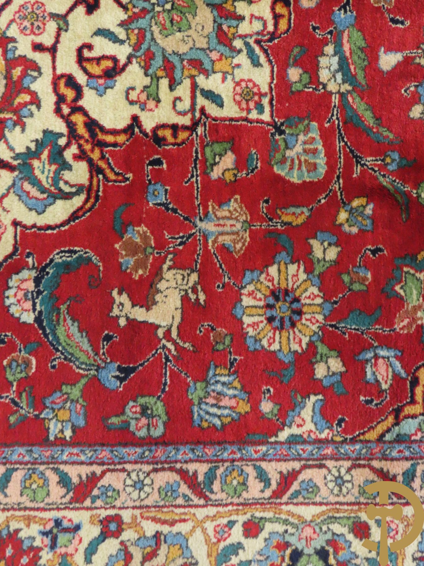 Oosters handgeknoopt tapijt met bloemen, dierenmotieven en centraal decor op rode fond