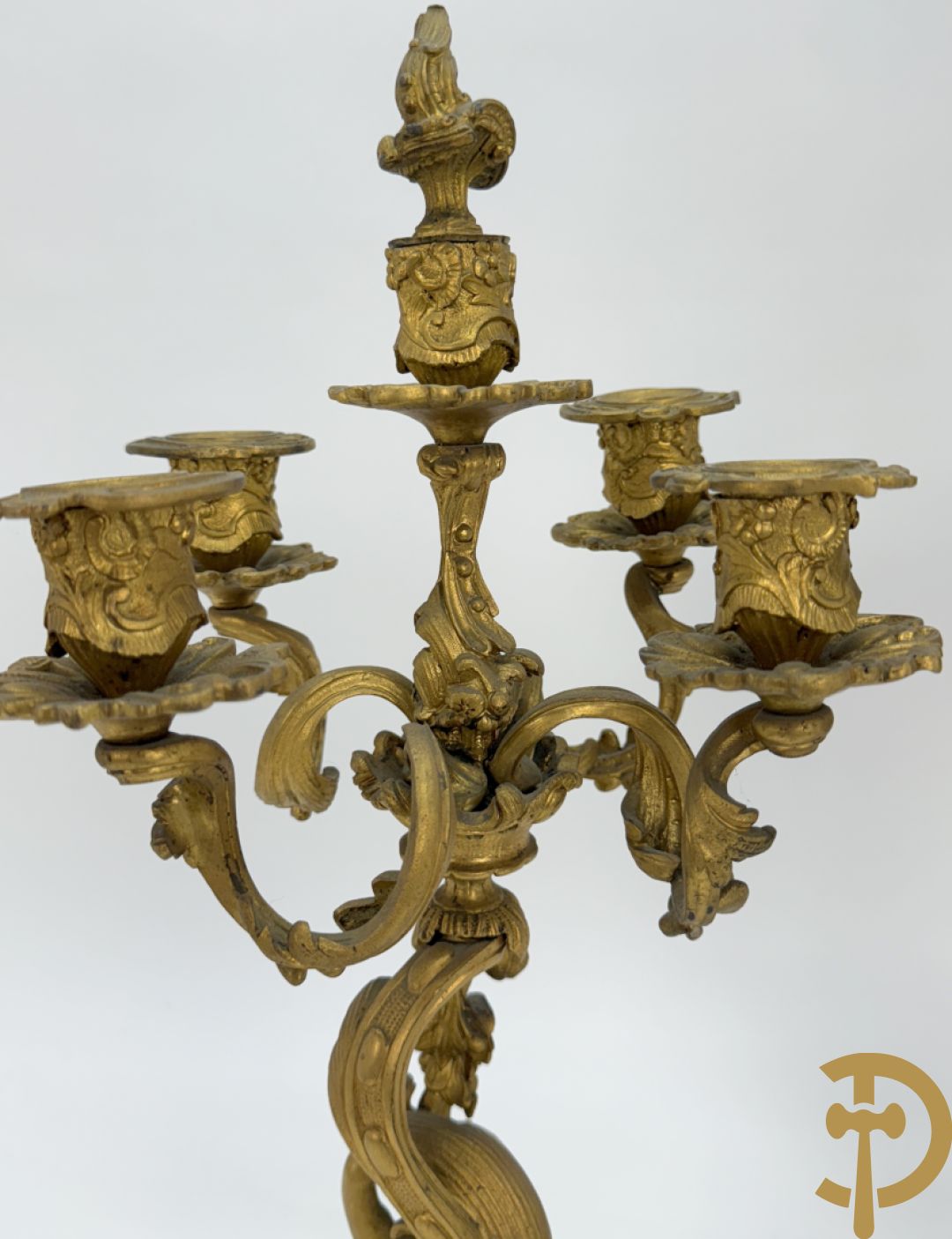 Driedelige vuurvergulde bronzen garnituur, Louis XV stijl, bestaande uit middenstuk met klok omgeven door musicerende cupido