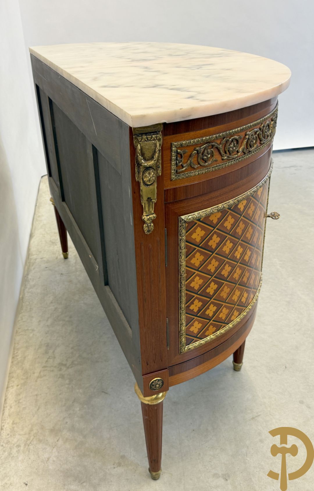 Halve maanvormige drieladencommode met 2 zijdelingse deuren, gemarketteerde bloemenmotieven en bronzen ornamenten, bovenaan bezet met marmeren blad