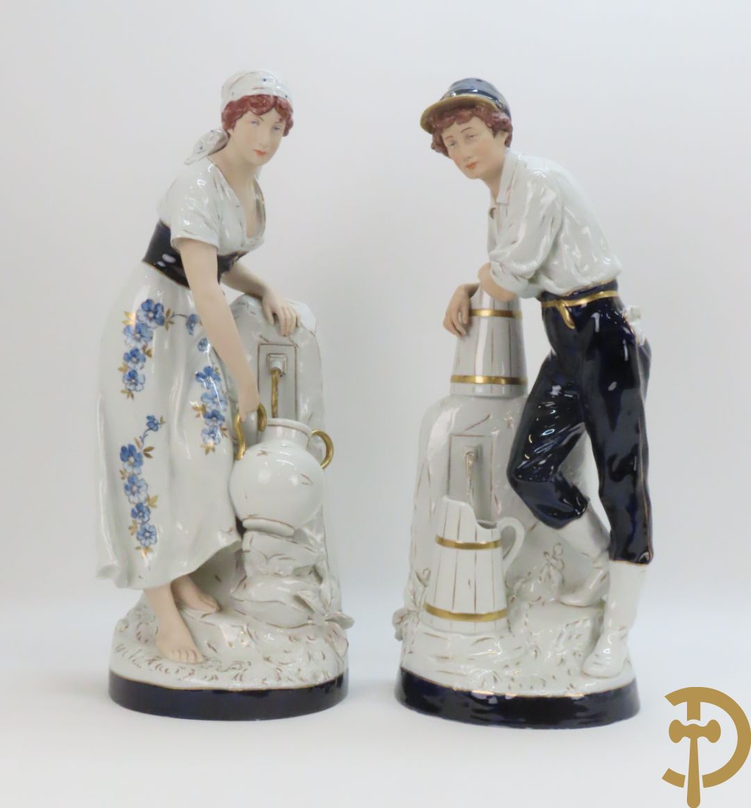 Paar Royal Dux personages van dame en heer bij de waterkraan, onderaan gemerkt en genummerd 10965 en 10563