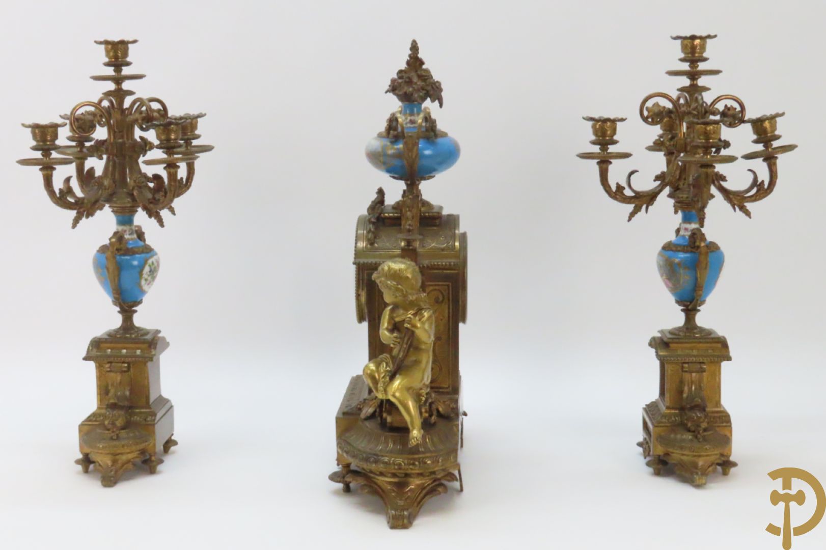 Driedelige bronzen garnituur bezet met Sèvres porselein bestaande uit pendule geflankeerd door paar cupido