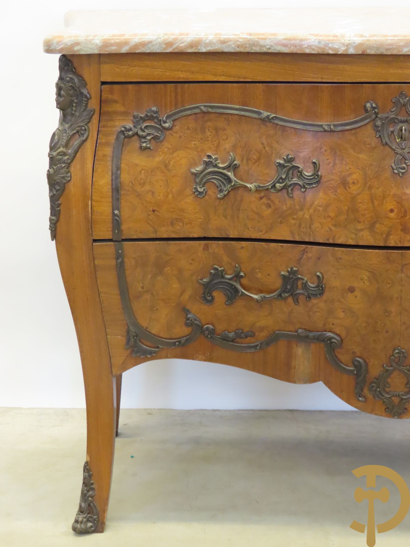 Wortelnotehouten gegalbeerde tweeladencommode met bronzen accanthusranken op lades, bronzen trekkers en dameshoofden opzij