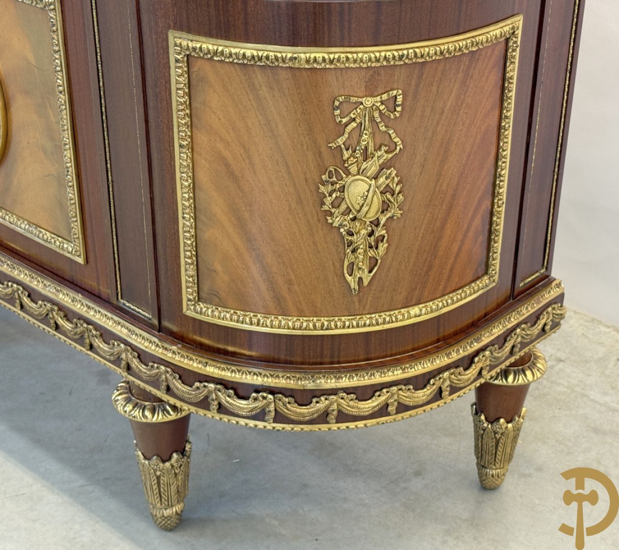 Notelaren vitrine met afgeronde zijkanten, bezet met bronzen plakkettes van dame en cupido