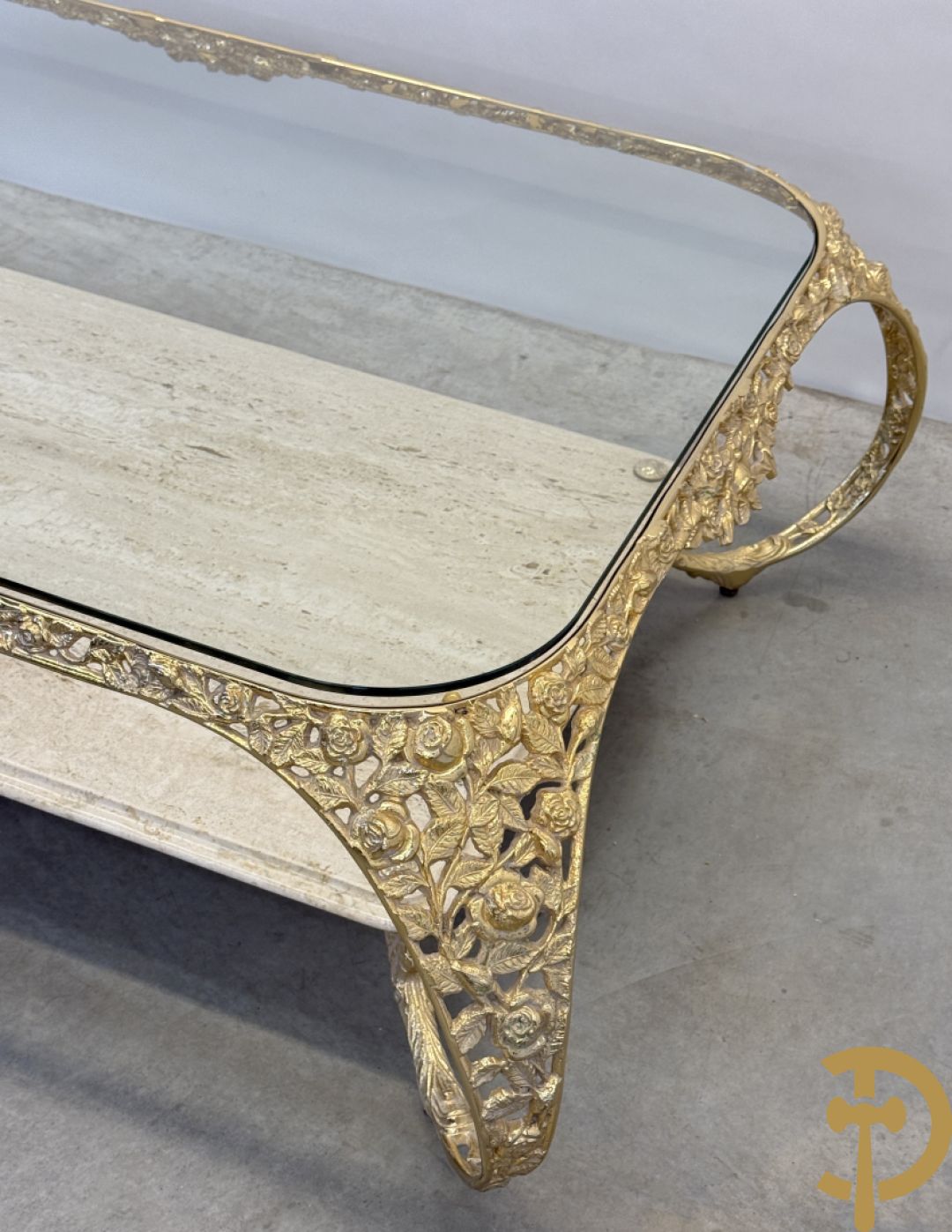 Salontafel met glazen blad op gebogen voluutvormige koperen poten gemaakt van bladranken - onderaan met travertin blad