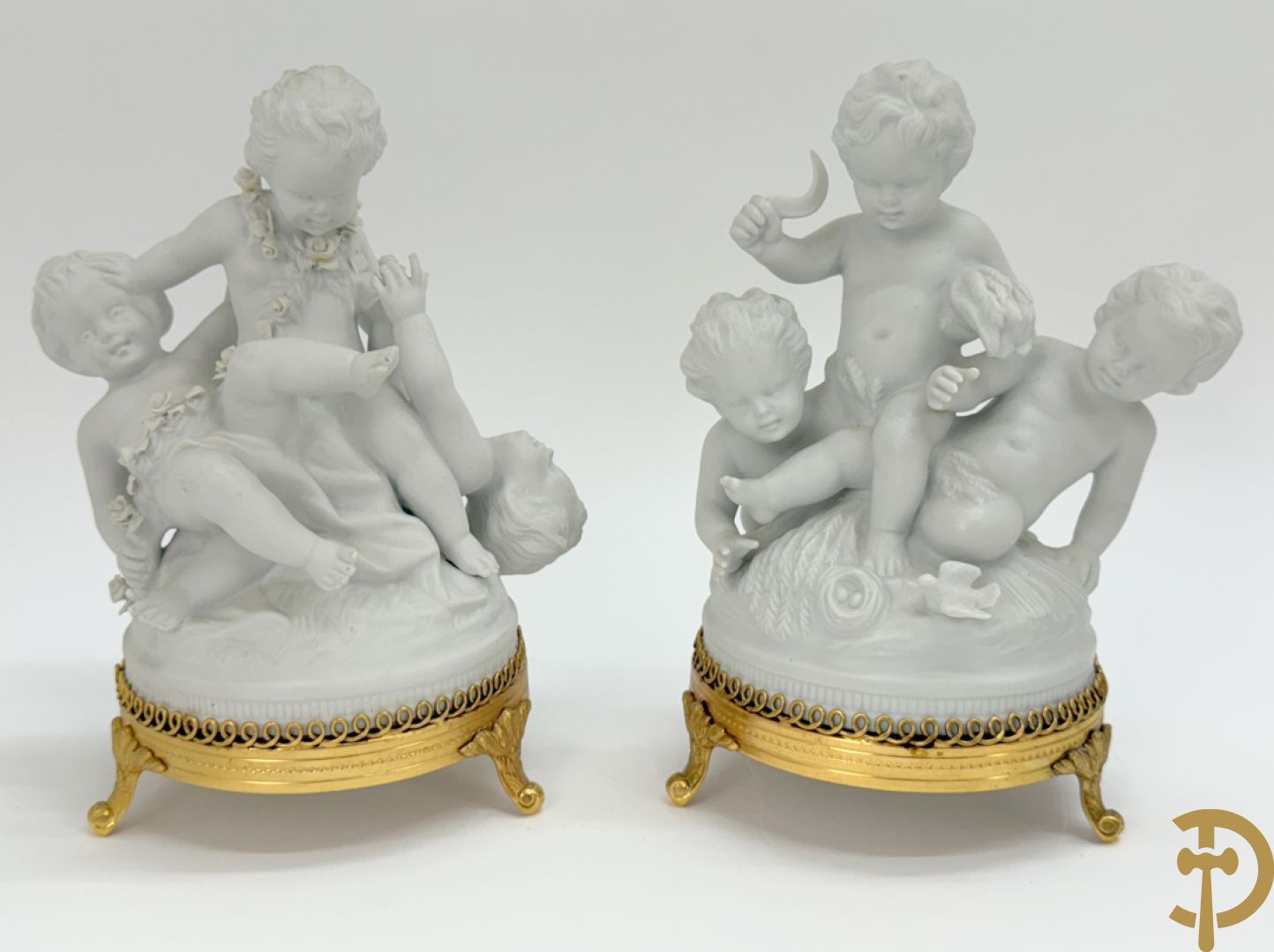 Zeven witte biscuits met voorstelligen van spelende kinderen en engelen op vergulde koperen sokkel, gemerkt Unterweisbach