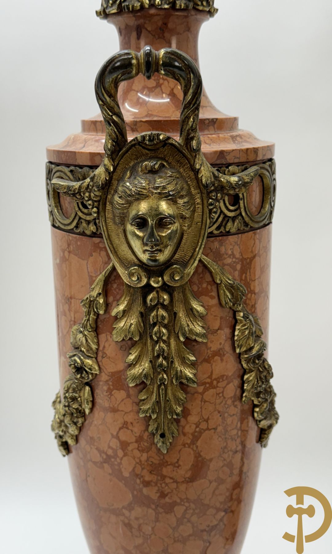 Paar oranje/rode marmeren cassolettes, zijdelings bezet met dameshoofden dragende een guirlande van bloemen - bovenaan met bloementroffee