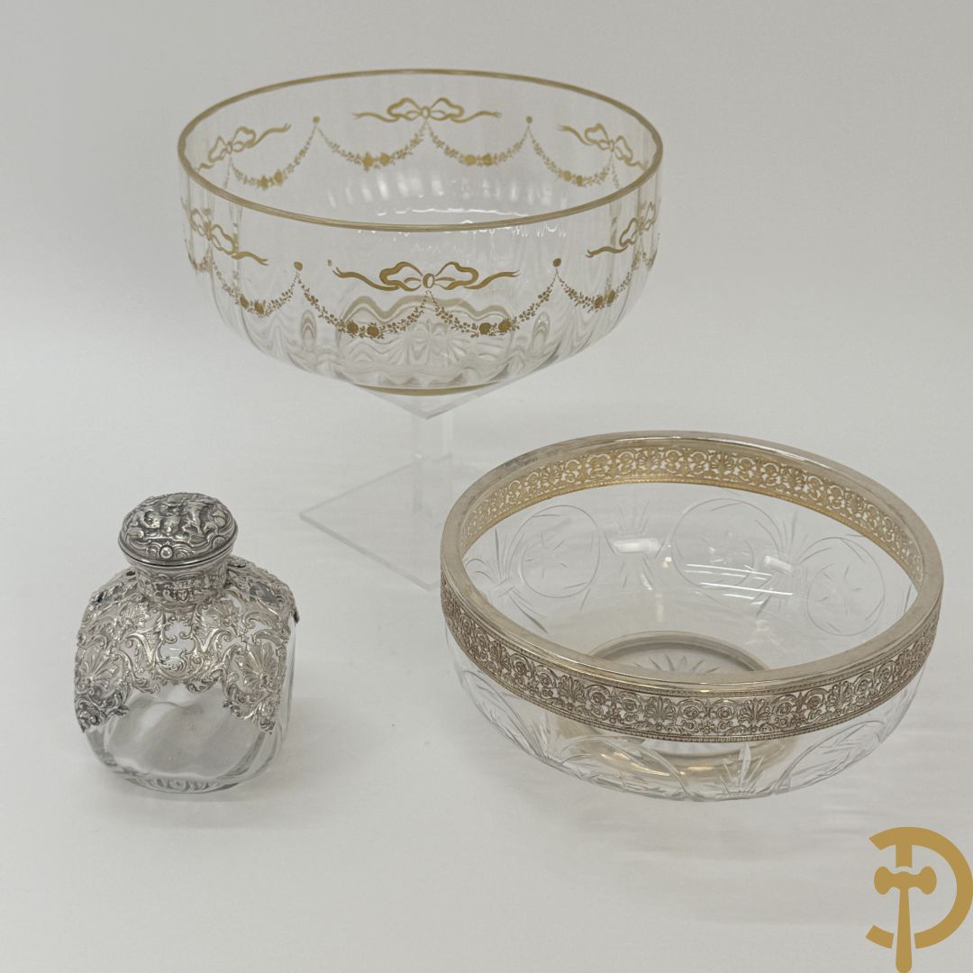 Kristallen flacon met verzilverd omhulsel en geanimeerd tafereel + kristallen coupe met verzilverde rand + kristallen coupe met vergulde louis XVI strikken en guirlandes