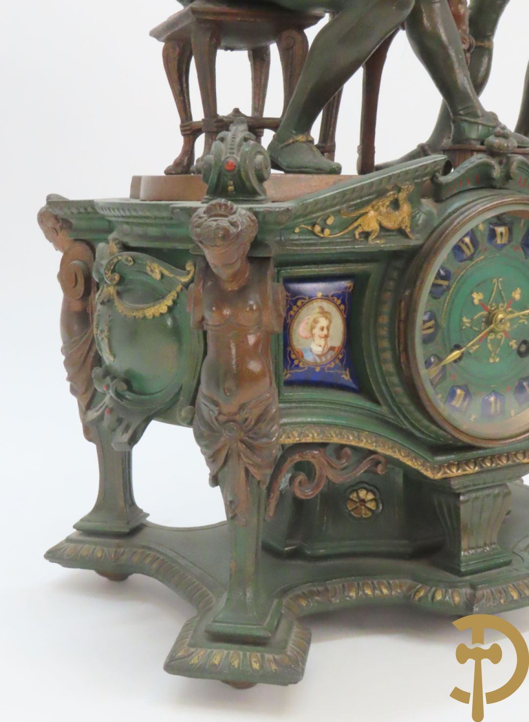 Driedelige kunstbronzen garnituur bestaande uit pendule met paar schakende edelheren, bezet met kariatiden - geflankeerd door paar driearmige kandelaars gehouden door 2 edelheren