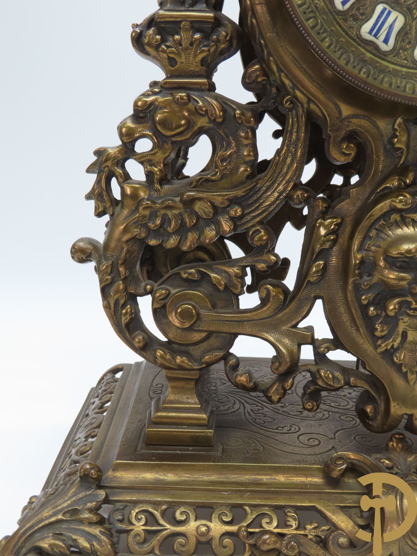 Driedelige bronzen garnituur bestaande uit middenstuk bezet met accanthusranken, drakenmotieven en leeuwenkoppen geflankeerd door paar kandelaars met hermenfiguren en accanthusranken