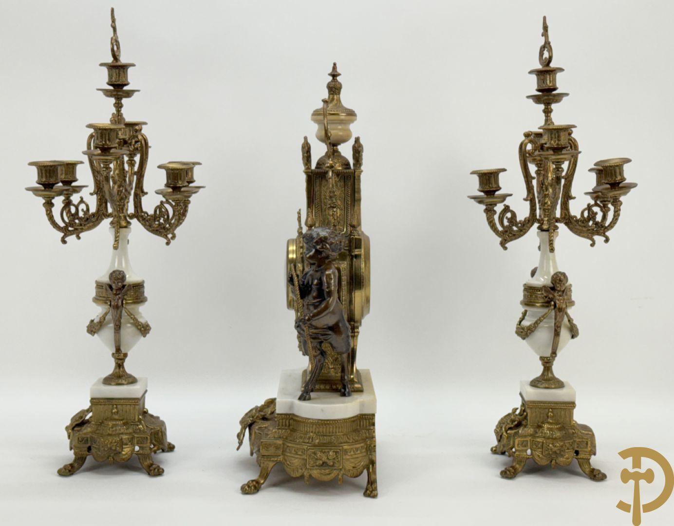 Driedelige koperen garnituur, centraal met harp geflankeerd door paar cupido