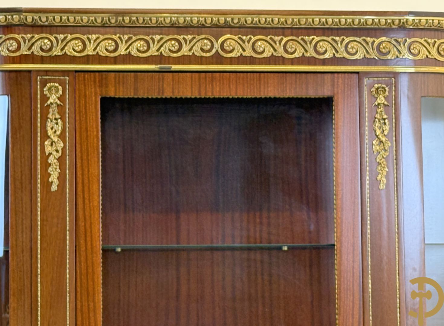 Notelaren vitrine met afgeronde zijkanten, bezet met bronzen plakkettes van dame en cupido