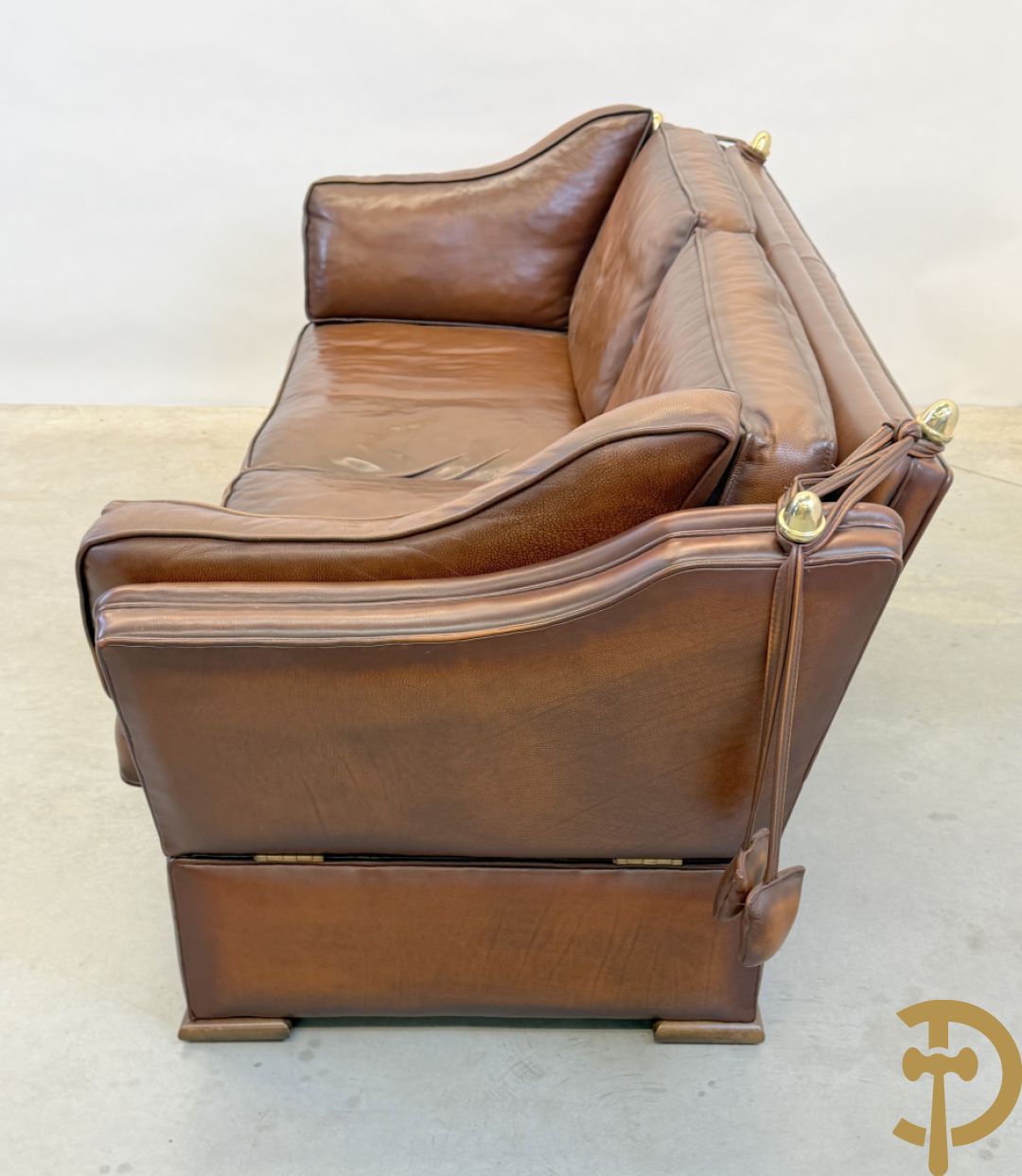 Bruin lederen canapé met kantelbare zijkanten en koperen denappels