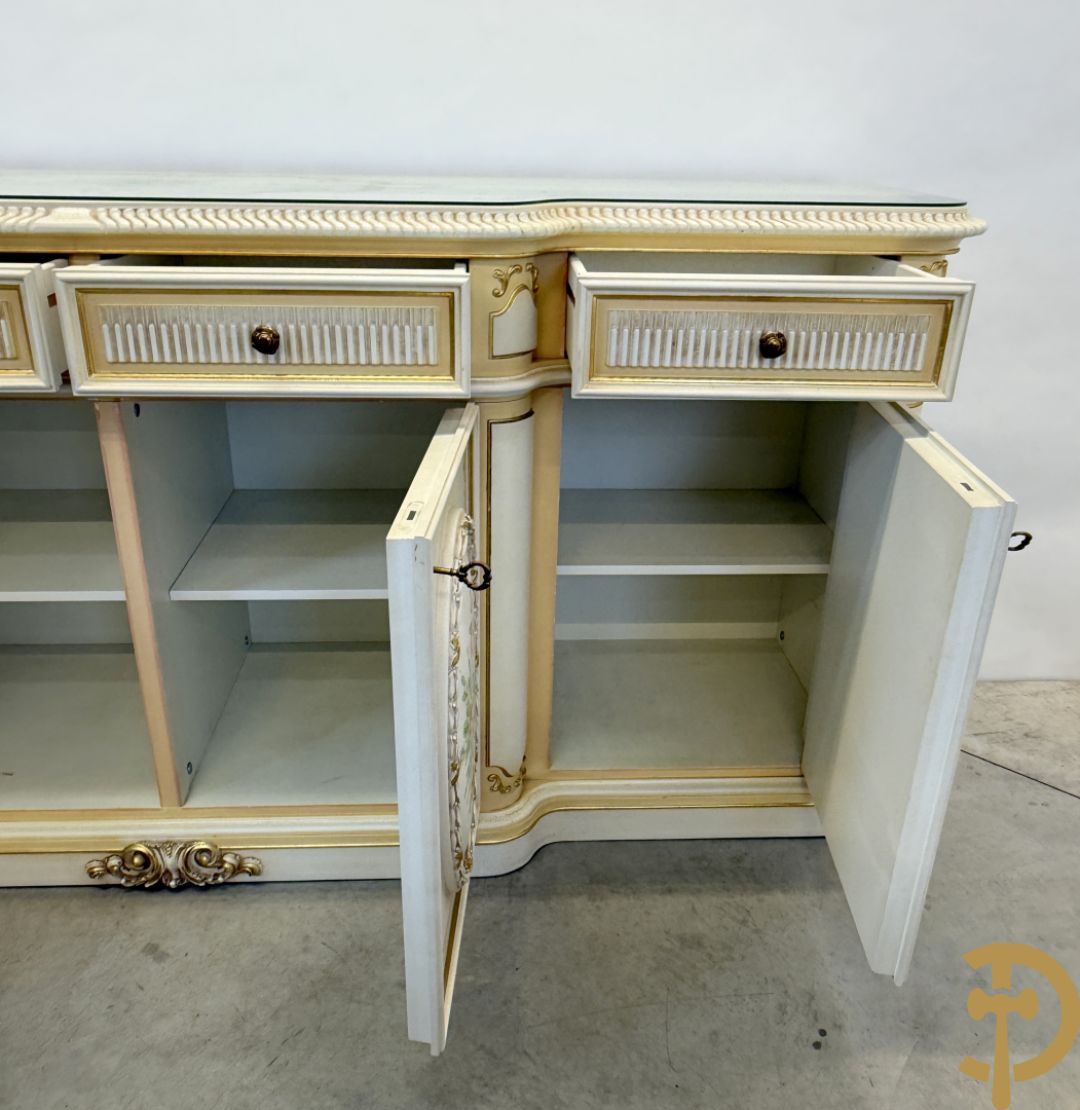 Italiaanse eetkamer met beschilderd bloemenmotief bestaande uit vierdeursdressoir met beschilderde bloemenmotieven, accanthusranken en glazen blad, tafel op gesculpteerde poten en 6 stoelen