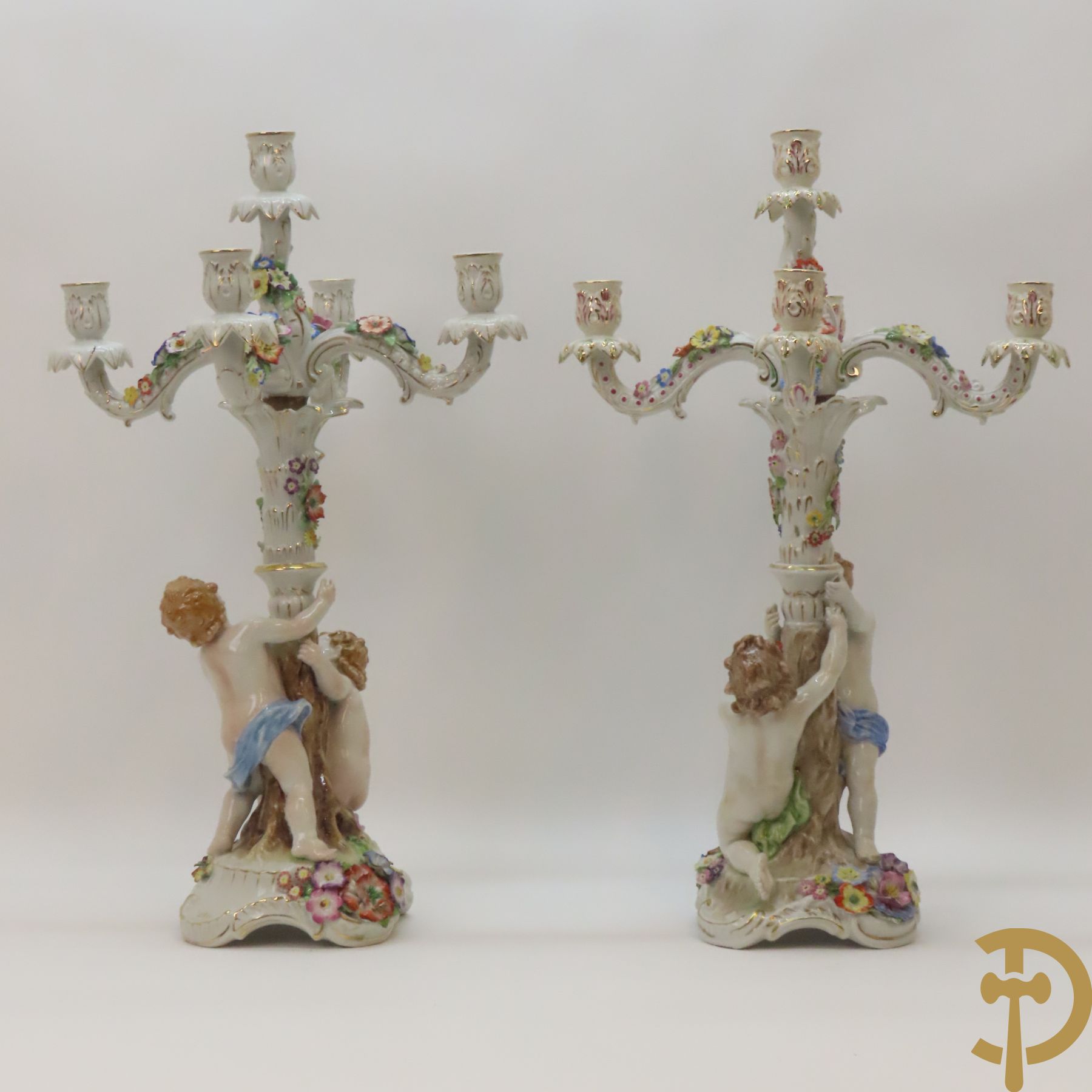 Twee porseleinen vijfarmige kandelaars met cupido