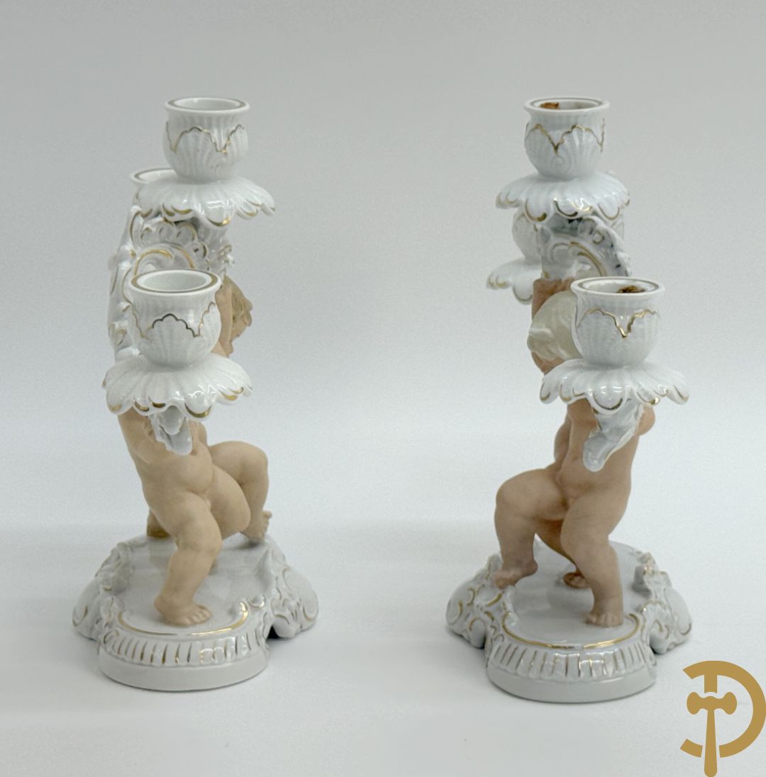 Twee kandelaars in biscuit met cupido