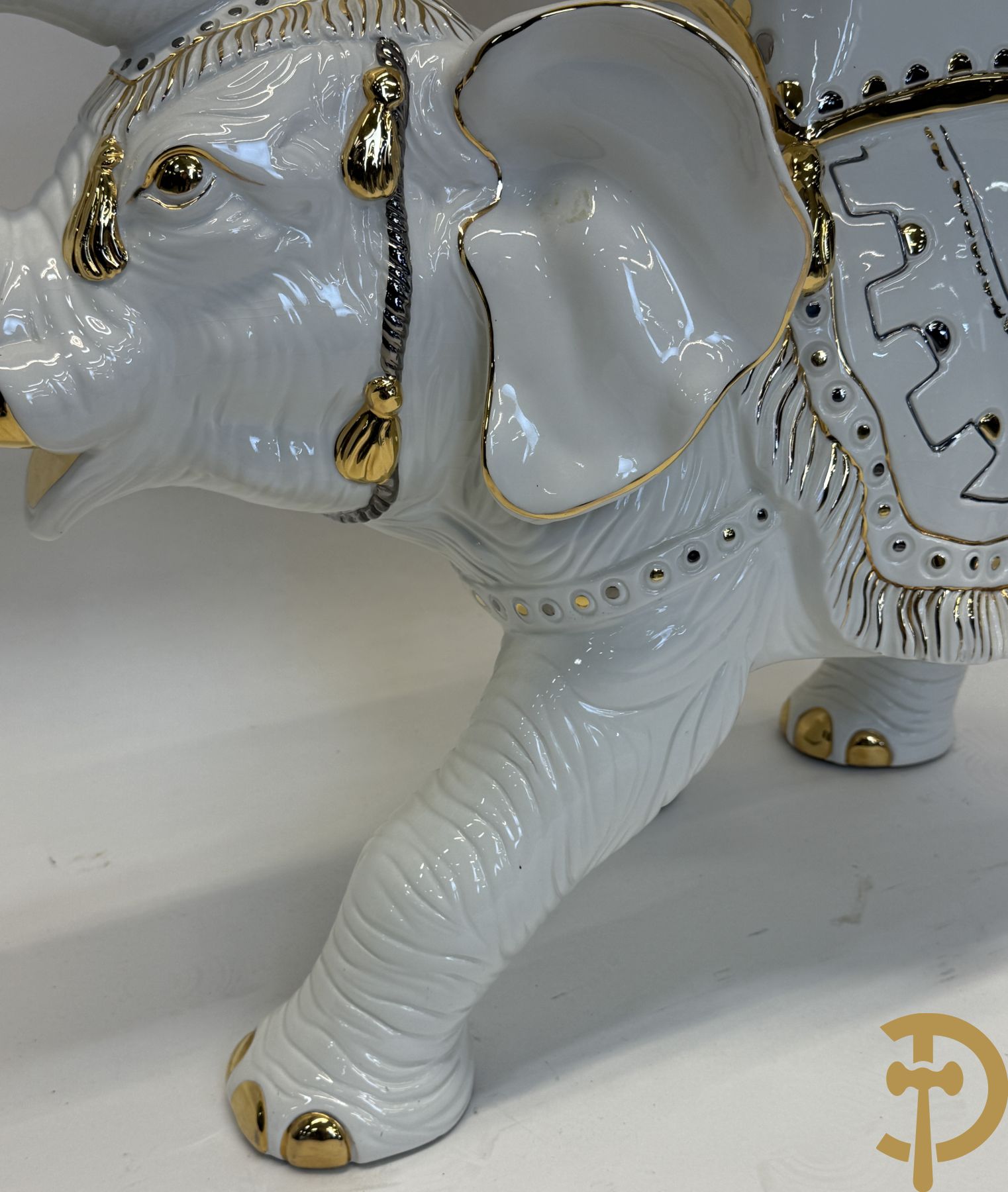 Porseleinen sierbeeld van olifant als staander met daarboven jongeman met bloemencachepot