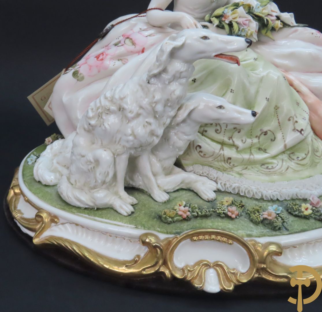 Italiaans porseleinen sierbeeld van zittende dame met 2 windhonden, L. Cazzola getekend en Capo di Monte gemerkt achteraan