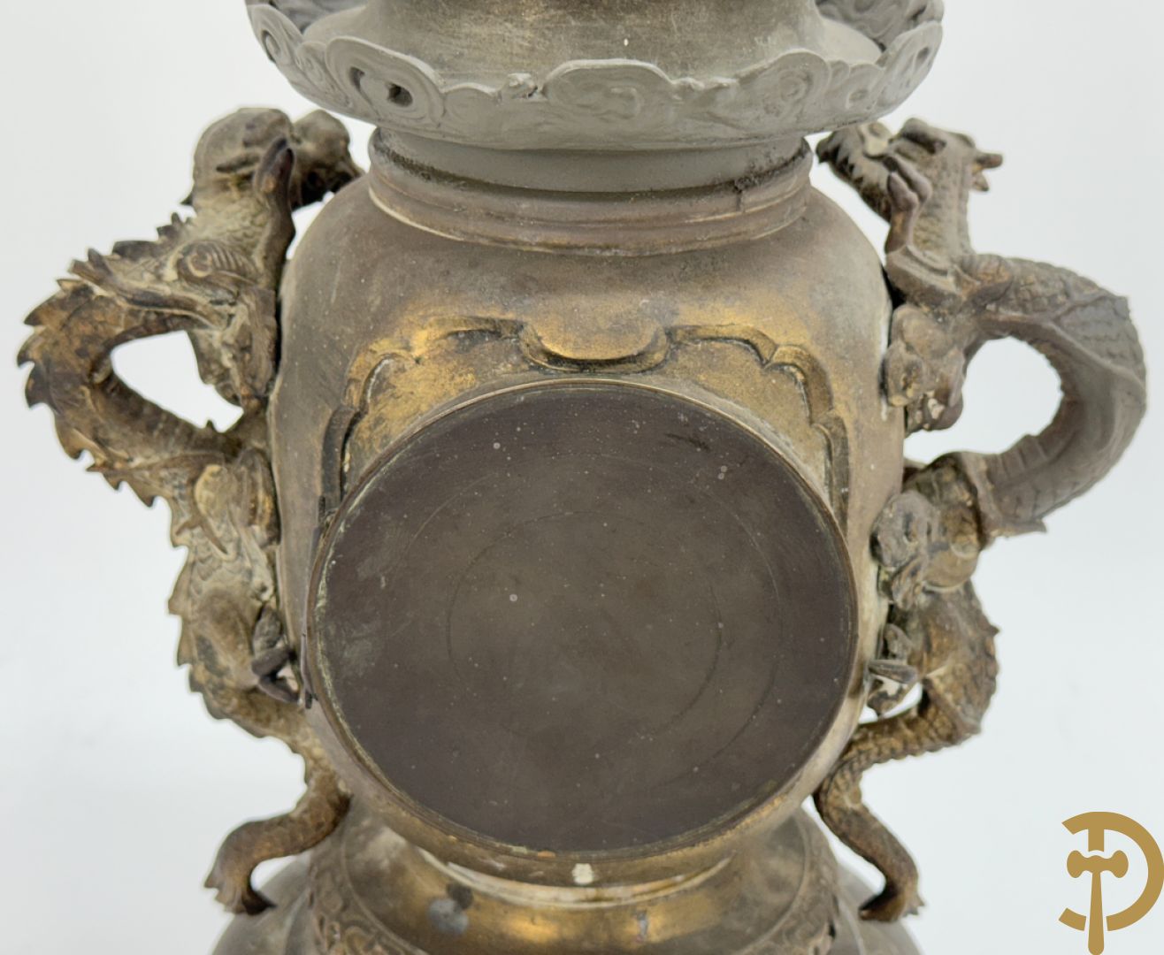 Aziatische pendule in zamak, zijdelings bezet met drakendecor en bovenaan met mythologisch figuur